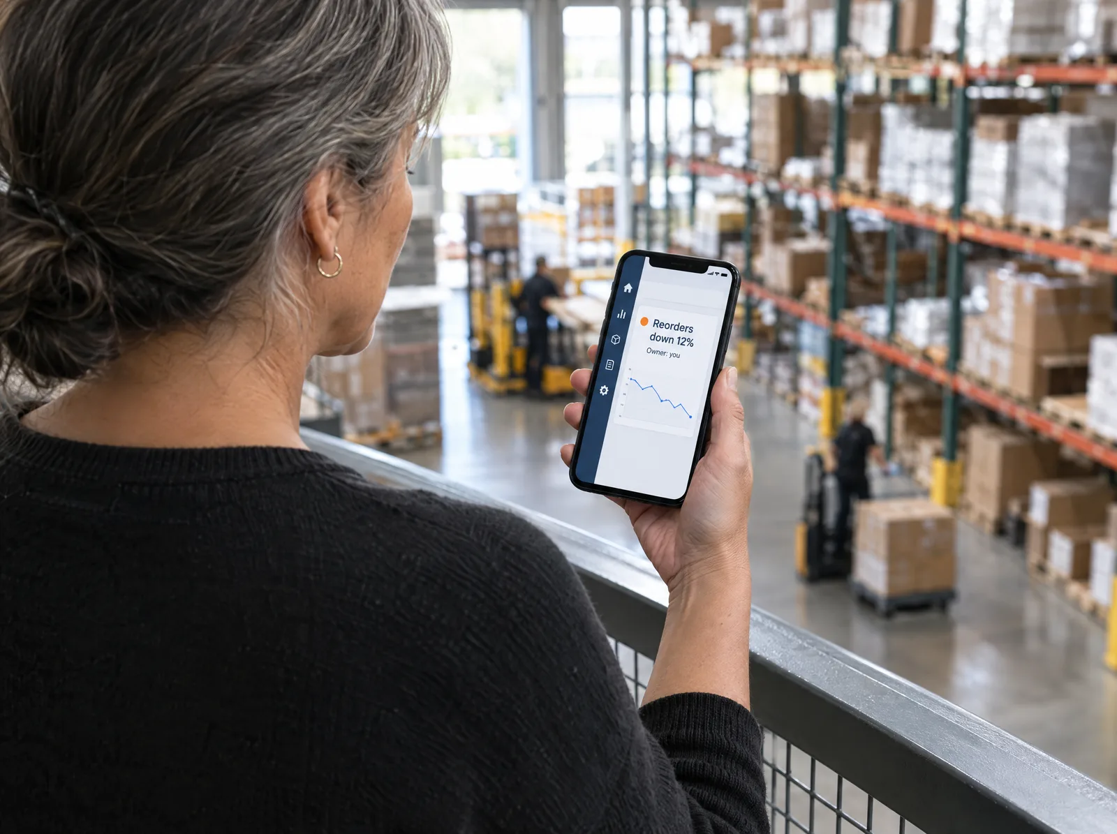 Sales manager reading a phone alert that online reorders dropped this week Sales manager reading a phone alert that online reorders dropped this week