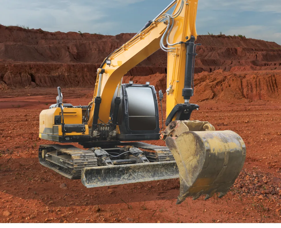 A yellow excavator on a red dirt job site