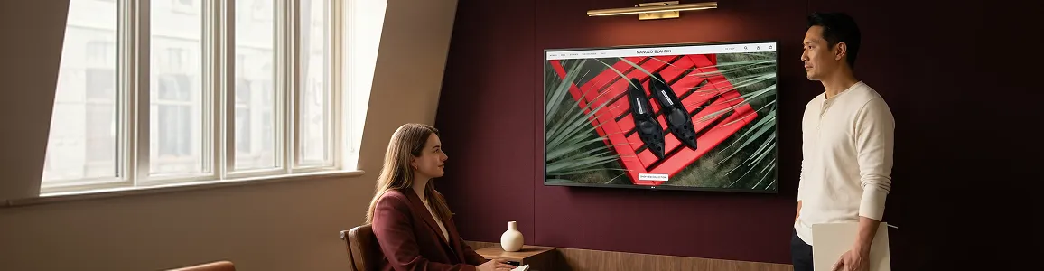 Redefine designer presenting a newly launched Adobe Commerce storefront design on a large monitor, relaxed natural light Redefine designer presenting a newly launched Adobe Commerce storefront design on a large monitor, relaxed natural light