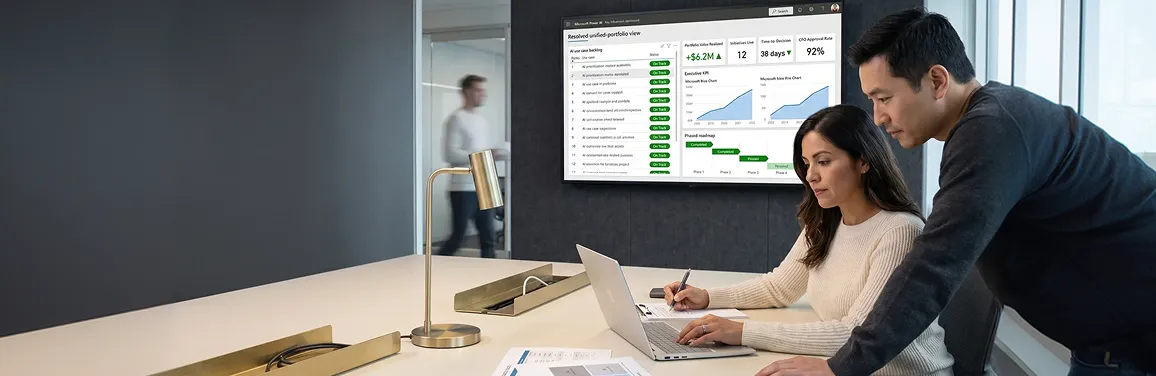 Calm ops director and program lead reviewing a unified AI portfolio dashboard with green on-track KPIs after AI strategy consulting