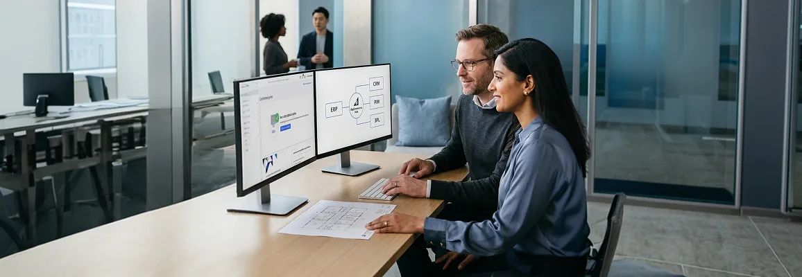 IT director and COO reviewing BigCommerce integration architecture on dual monitors in a modern office IT director and COO reviewing BigCommerce integration architecture on dual monitors in a modern office