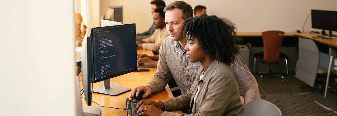 Two engineers pair-programming at dual monitors in a modern development studio Two engineers pair-programming at dual monitors in a modern development studio