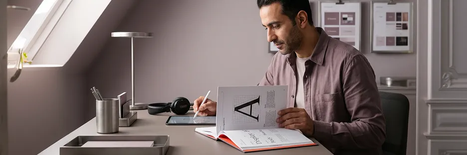 Brand lead reviewing a cohesive typography brand guideline spread at a calm studio desk Brand lead reviewing a cohesive typography brand guideline spread at a calm studio desk