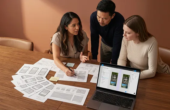 Designer presenting annotated wireframes to marketing team at conference table, warm desk light Designer presenting annotated wireframes to marketing team at conference table, warm desk light