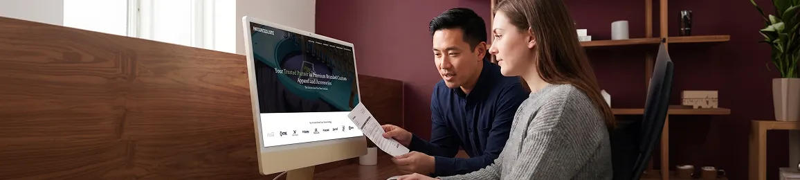 Parsons Kellogg ecommerce team reviewing WooCommerce order dashboard and product catalog on desktop in professional office with natural light Parsons Kellogg ecommerce team reviewing WooCommerce order dashboard and product catalog on desktop in professional office with natural light