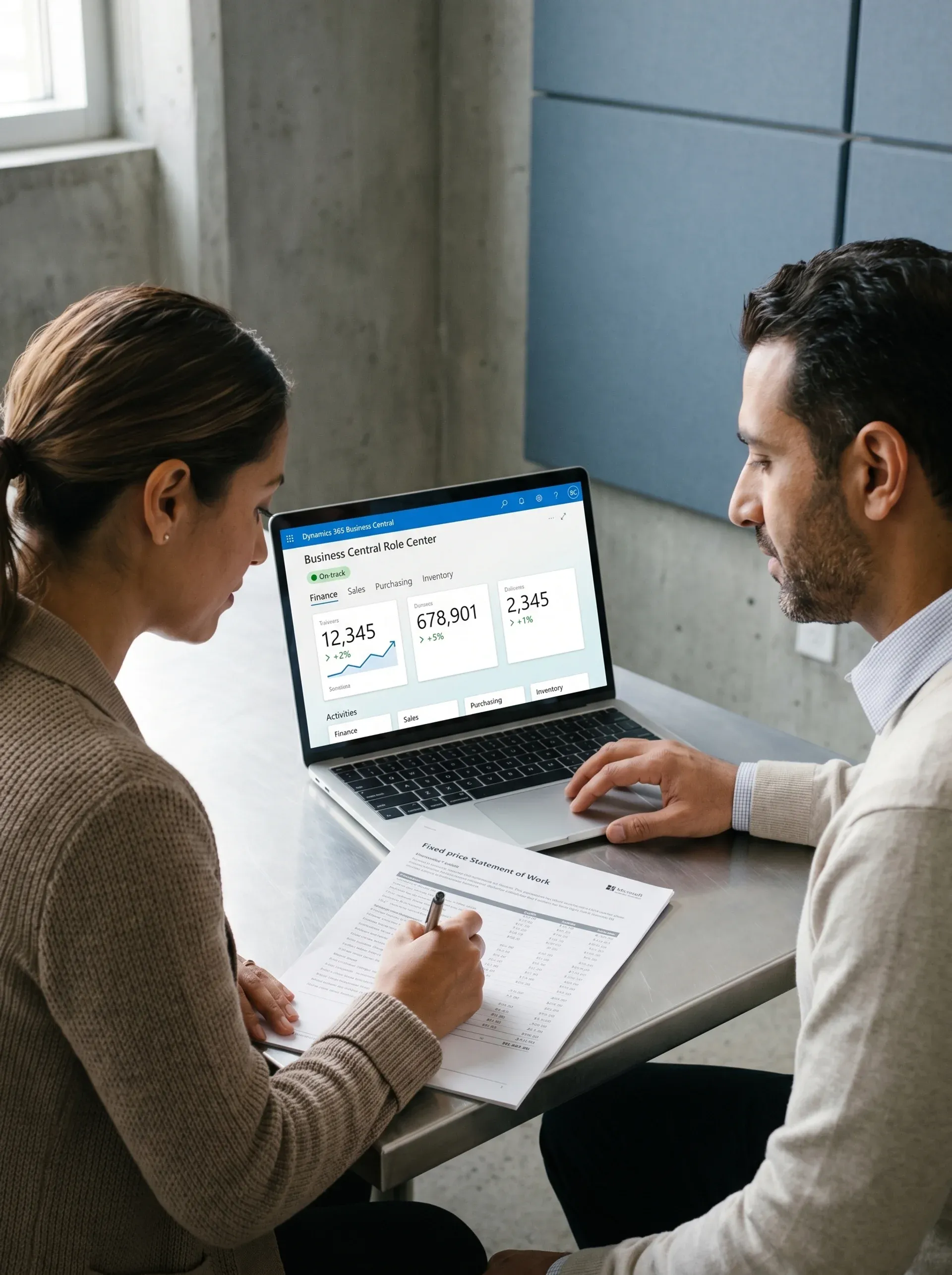 Two professionals reviewing ERP implementation quotes and project scope documents together at a desk Two professionals reviewing ERP implementation quotes and project scope documents together at a desk