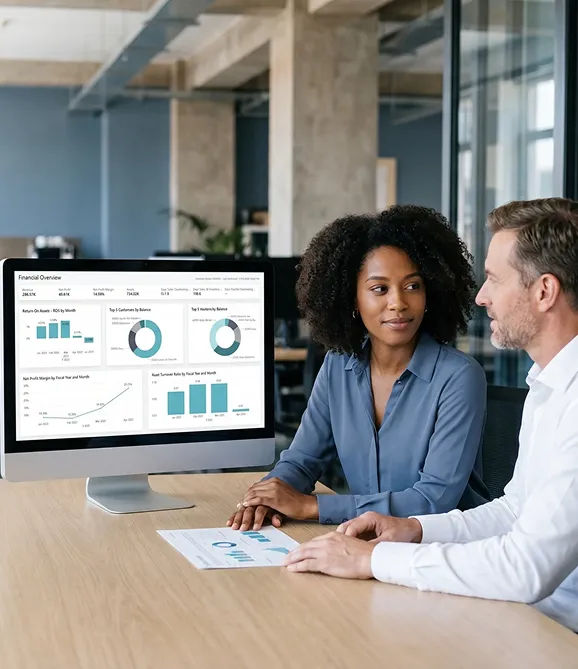 Finance team reviewing a live Power BI executive dashboard on a wide screen after Dynamics 365 reporting go-live Finance team reviewing a live Power BI executive dashboard on a wide screen after Dynamics 365 reporting go-live