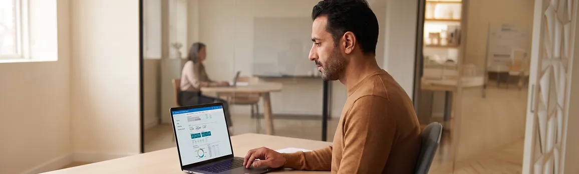 Finance director at a desk reviewing the NAV to Business Central migration assessment report, three-quarter angle, natural daylight Finance director at a desk reviewing the NAV to Business Central migration assessment report, three-quarter angle, natural daylight