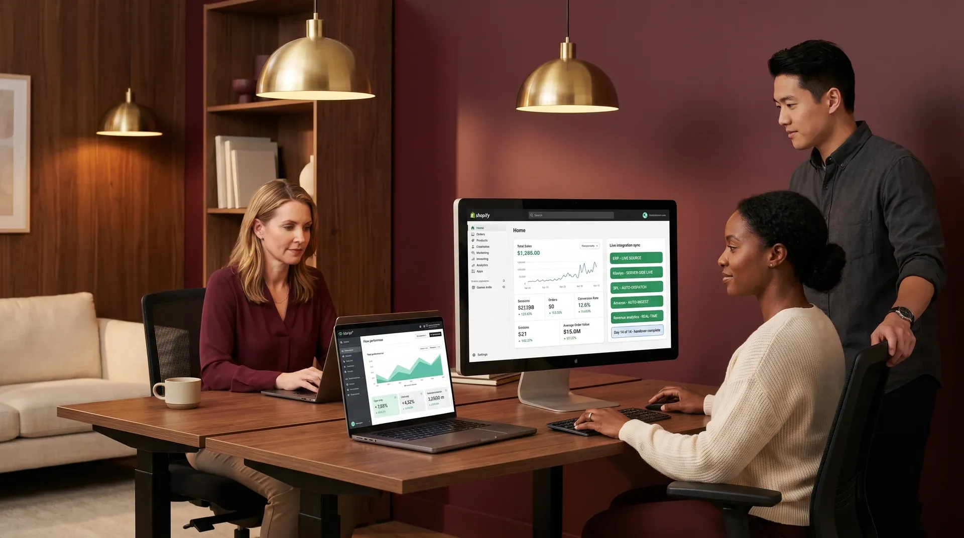 Shopify merchant team at integration go-live handover moment with multiple screens showing live Shopify admin and Klaviyo flow analytics dashboards, deep burgundy and walnut ambient office light Shopify merchant team at integration go-live handover moment with multiple screens showing live Shopify admin and Klaviyo flow analytics dashboards, deep burgundy and walnut ambient office light