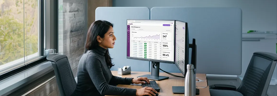 Ecommerce operations lead reviewing Wayfair marketplace order dashboard at a workstation with dual monitors Ecommerce operations lead reviewing Wayfair marketplace order dashboard at a workstation with dual monitors