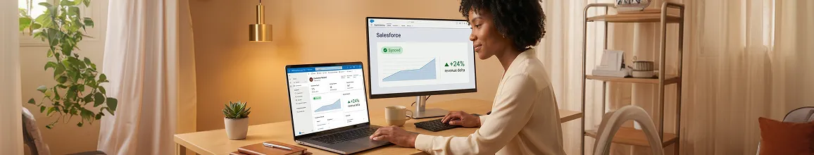 Revenue operations professional reviewing integrated Salesforce and Dynamics 365 data on dual monitors, natural light, wide angle Revenue operations professional reviewing integrated Salesforce and Dynamics 365 data on dual monitors, natural light, wide angle