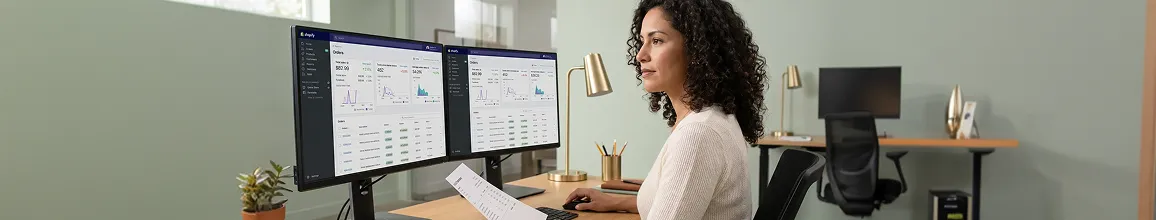 Operations manager reviewing unified order-to-fulfillment dashboard after integration with healthy KPIs and zero failures, calm focused expression, morning natural light