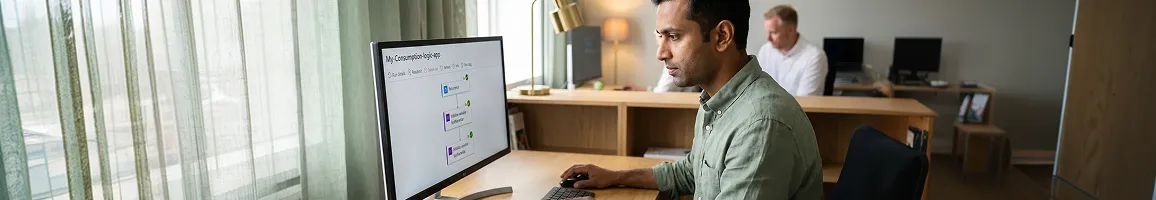 Integration consultant reviewing rescued integration code on large monitor with printed runbook documentation beside them, natural window light Integration consultant reviewing rescued integration code on large monitor with printed runbook documentation beside them, natural window light