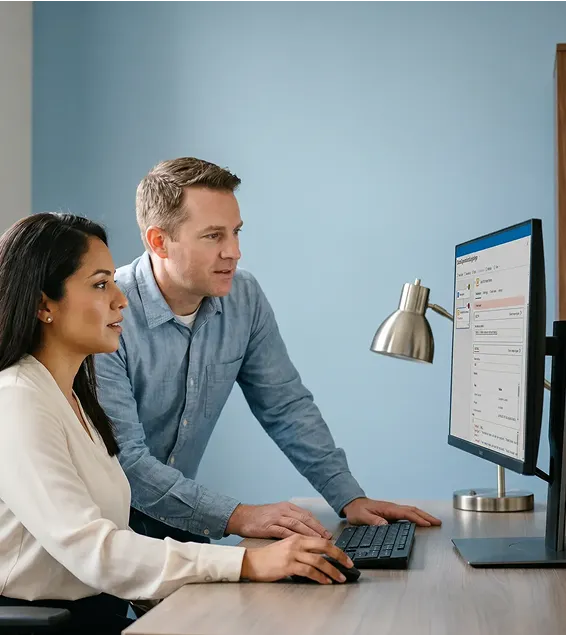 Two integration consultants reviewing diagnostic findings on large monitor together, focused expressions, natural window light Two integration consultants reviewing diagnostic findings on large monitor together, focused expressions, natural window light