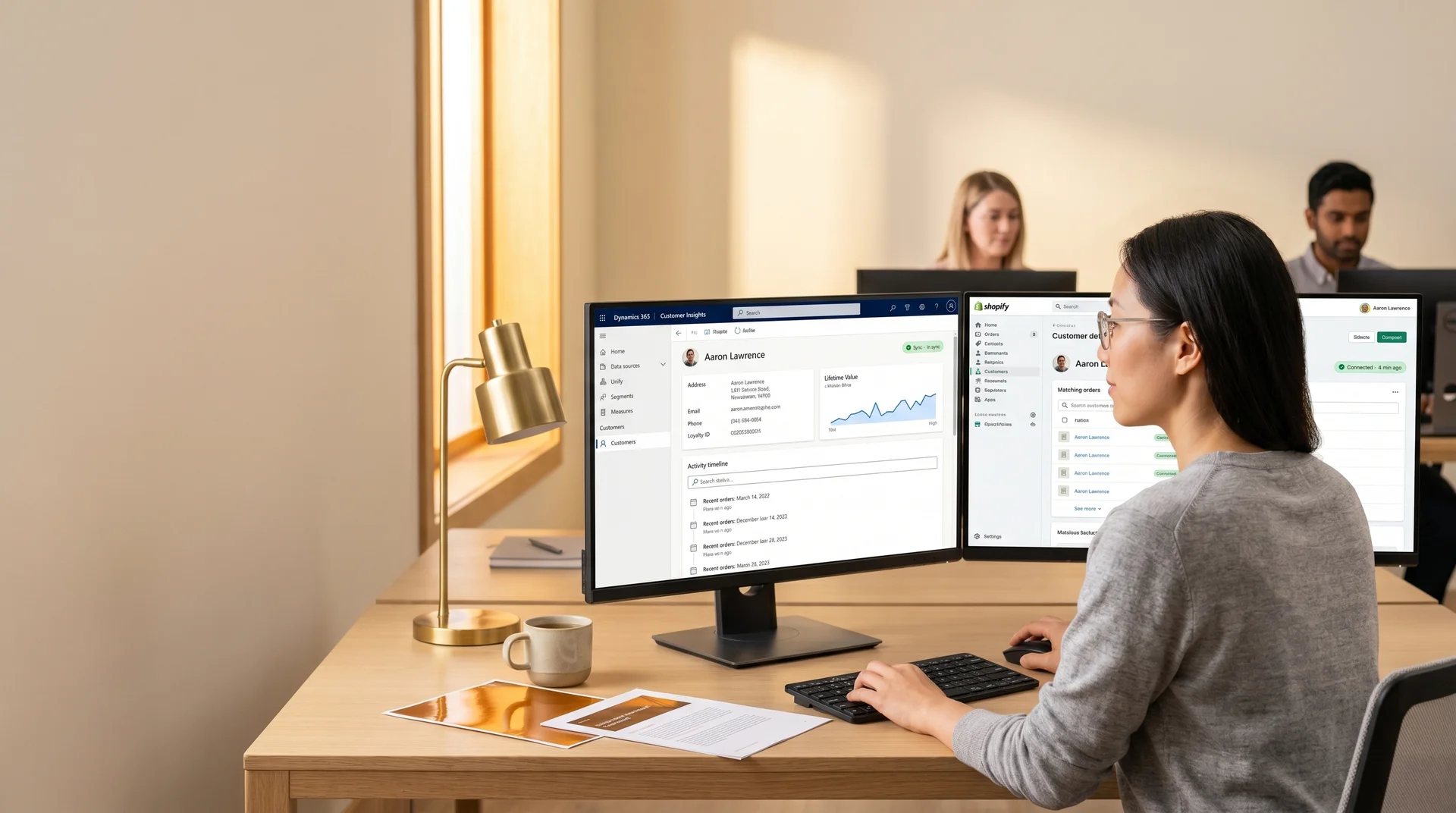 Data analyst reviewing unified customer profile data across multiple platforms on dual monitors in a naturally lit office environment Data analyst reviewing unified customer profile data across multiple platforms on dual monitors in a naturally lit office environment