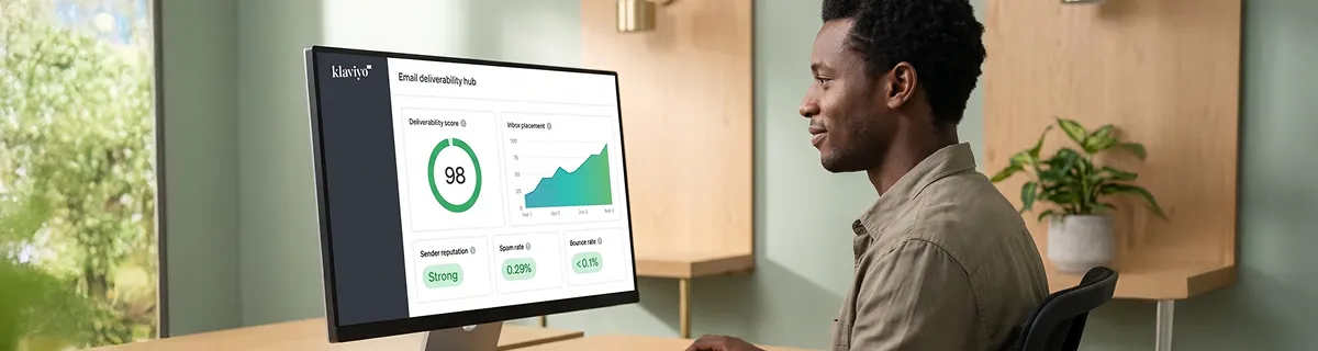 Email marketer reviewing healthy Klaviyo deliverability results on screen, office desk setting Email marketer reviewing healthy Klaviyo deliverability results on screen, office desk setting