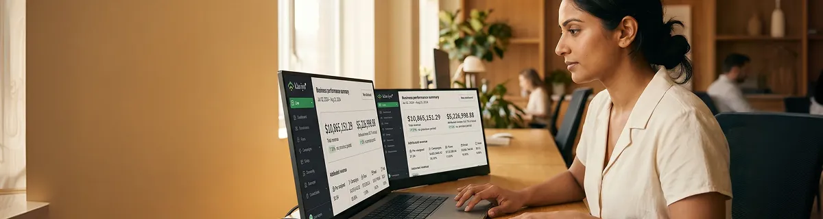 Ecommerce founder reviewing Klaviyo email revenue analytics on dual monitors, natural light