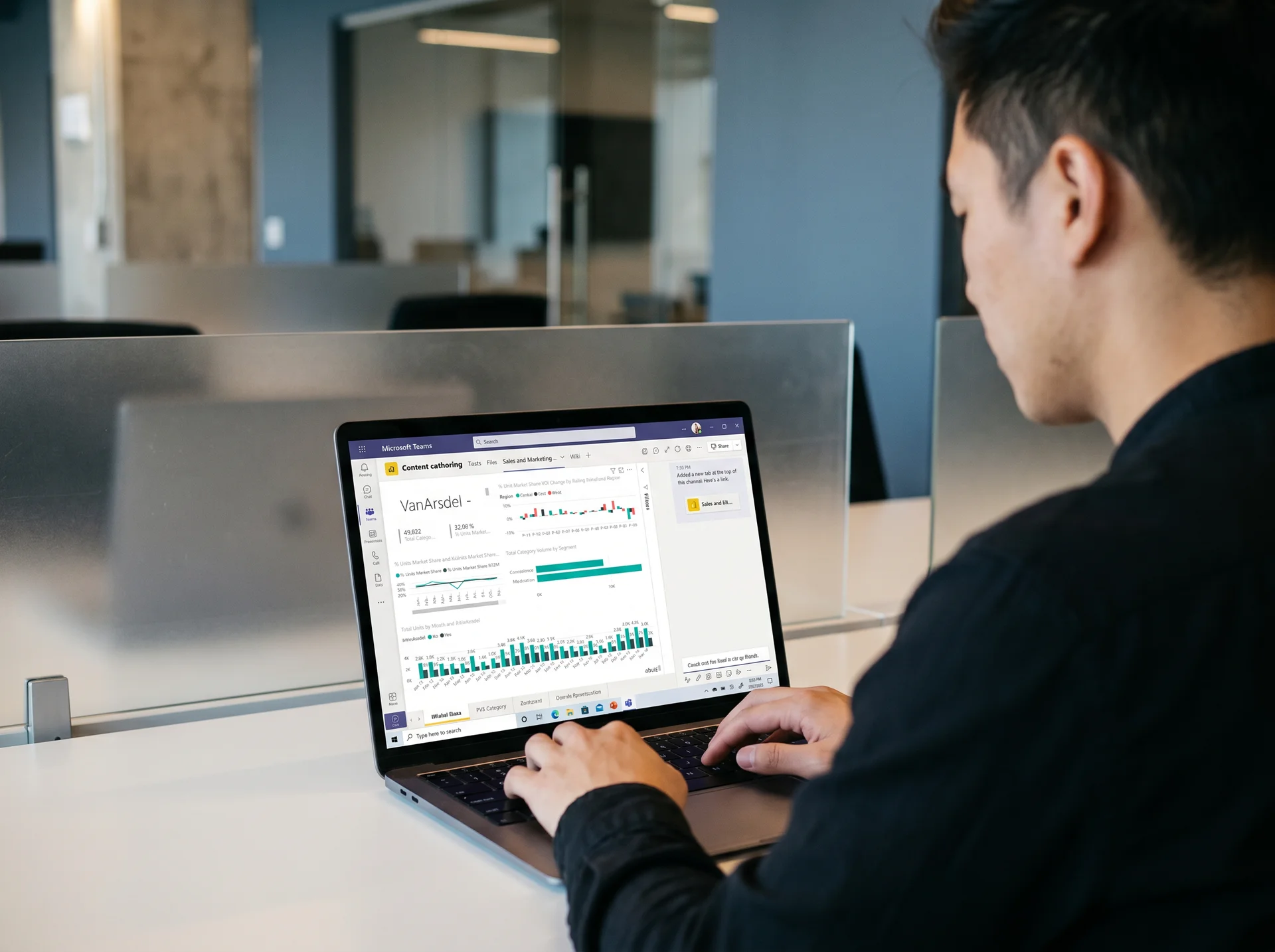 Analyst configuring a Power BI report as a pinned tab inside a Microsoft Teams channel, over-the-shoulder view on a laptop Analyst configuring a Power BI report as a pinned tab inside a Microsoft Teams channel, over-the-shoulder view on a laptop