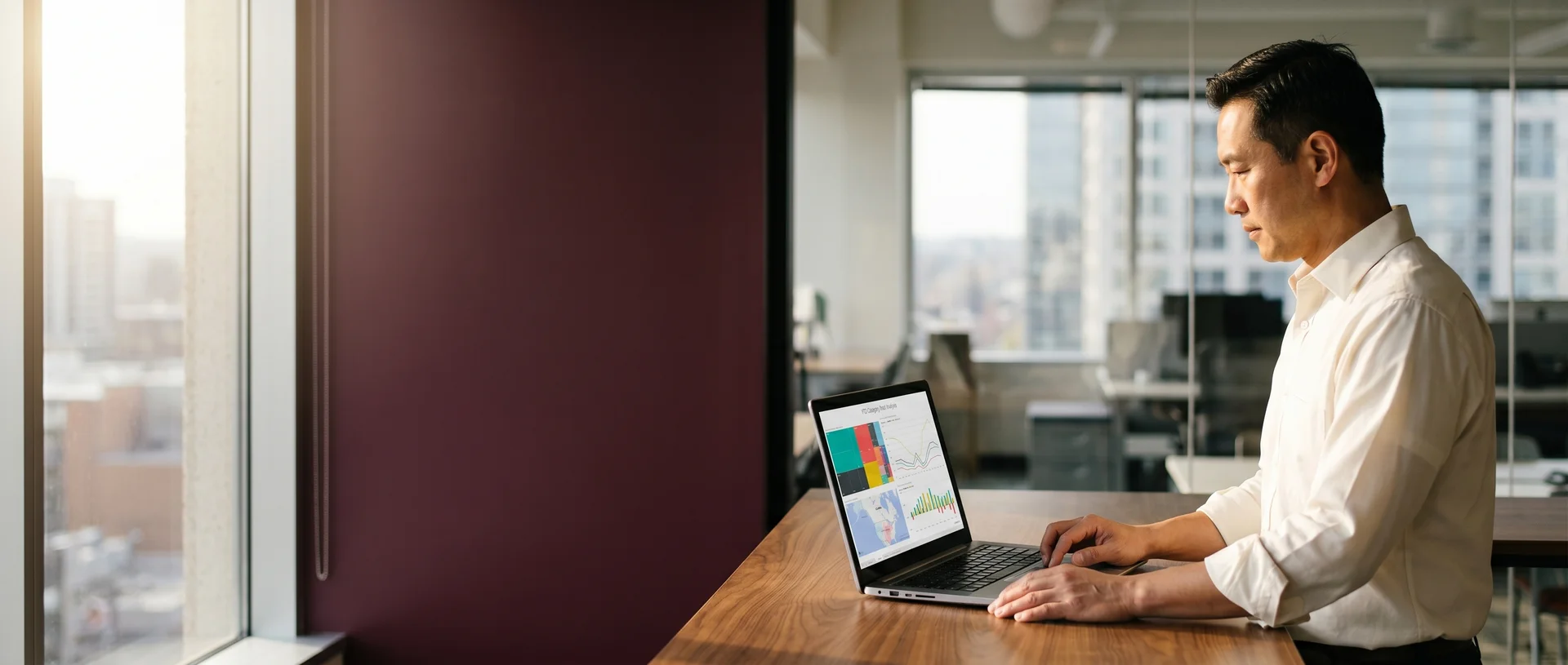 Executive reviewing live Power BI analytics on a laptop at a standing desk in morning light Executive reviewing live Power BI analytics on a laptop at a standing desk in morning light