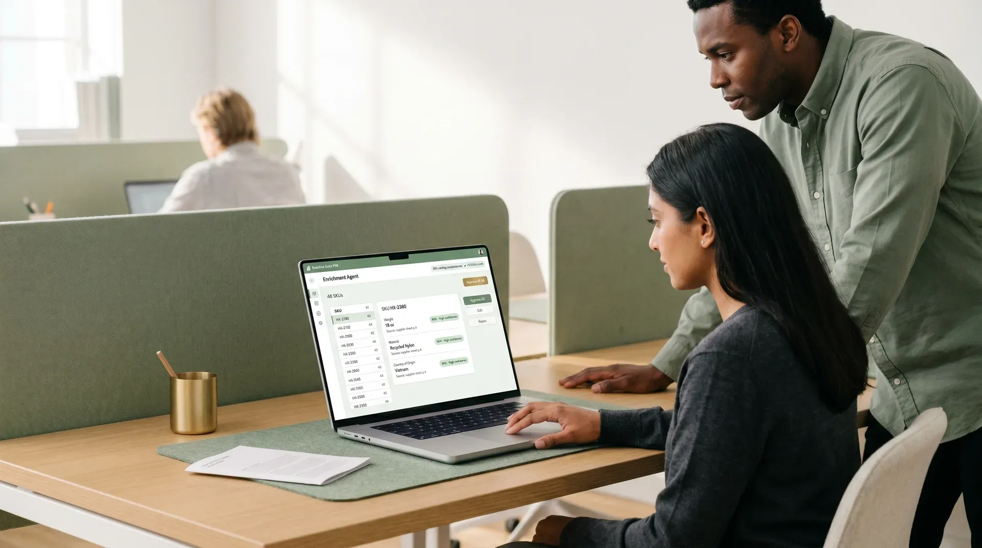 Two ecommerce operators calmly reviewing AI-assisted PIM enrichment decisions on a laptop, with a 96% confidence pill and approval queue visible