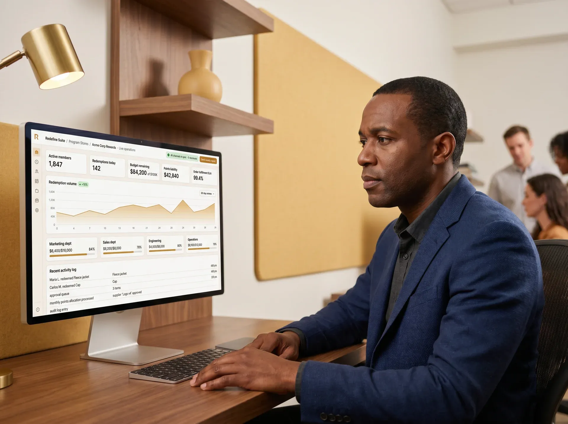 Program store administrator reviewing live redemption dashboard and budget utilization report on monitor Program store administrator reviewing live redemption dashboard and budget utilization report on monitor