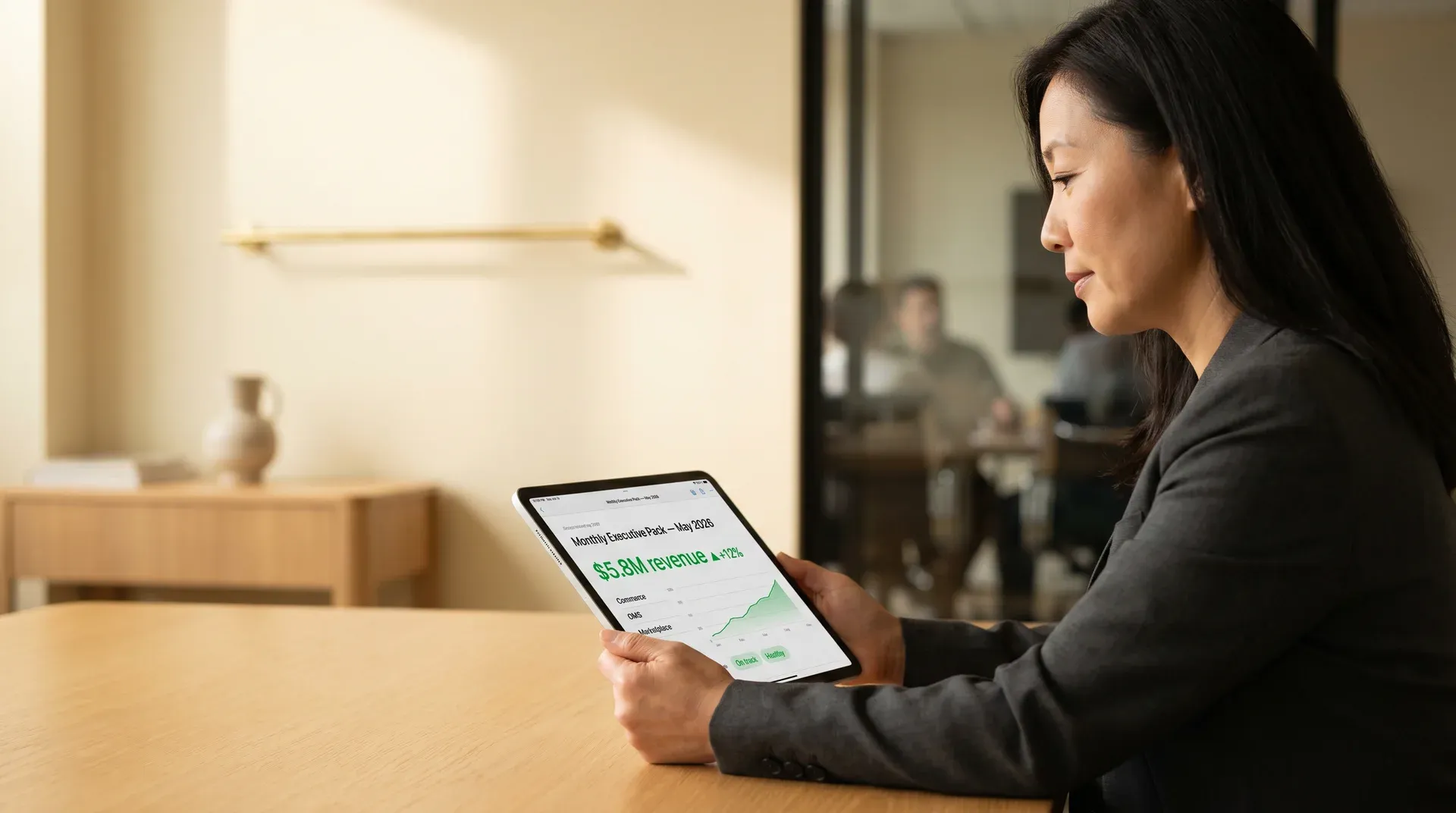 Executive reviewing a monthly scheduled PDF report on a tablet, showing revenue performance charts Executive reviewing a monthly scheduled PDF report on a tablet, showing revenue performance charts