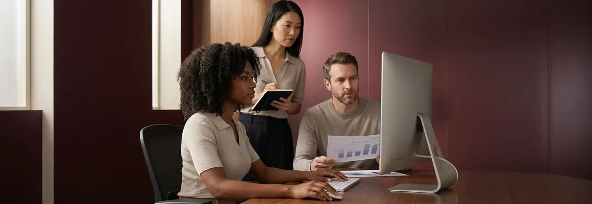 Brand team gathered around a monitor reviewing Shopify landing page designs together Brand team gathered around a monitor reviewing Shopify landing page designs together