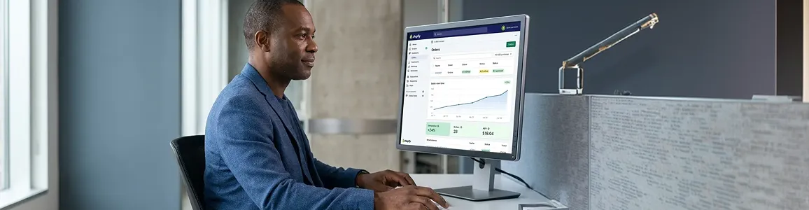 B2B operations director reviewing automated Shopify Plus wholesale orders in office B2B operations director reviewing automated Shopify Plus wholesale orders in office