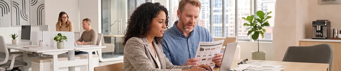 Trade buyer reviewing product pricing list with wholesale sales team in showroom Trade buyer reviewing product pricing list with wholesale sales team in showroom