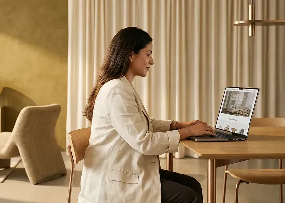 Home and furniture brand founder reviewing their new custom Shopify store on a laptop in a beautifully designed showroom, surrounded by their furniture collection, natural light and visible confidence Home and furniture brand founder reviewing their new custom Shopify store on a laptop in a beautifully designed showroom, surrounded by their furniture collection, natural light and visible confidence